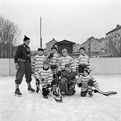 Sigge Löfgren med några av ungdomarna i hockeyturneringen på Brunnsrinken i Ronneby under sportlovet, februari 1959.